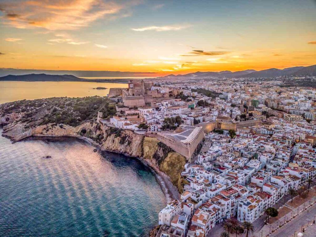 overhead shot of old town of ibiza at sunset with a fortress at the top of a hill