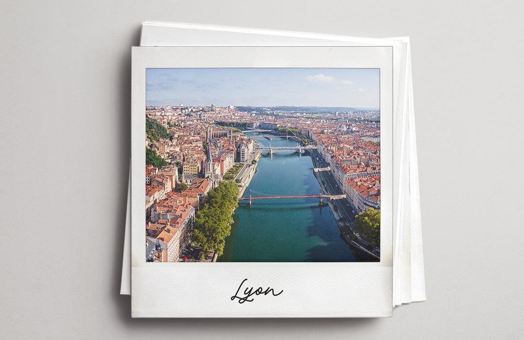 A polaroid aerial photo of Lyon with a river crossing the city.