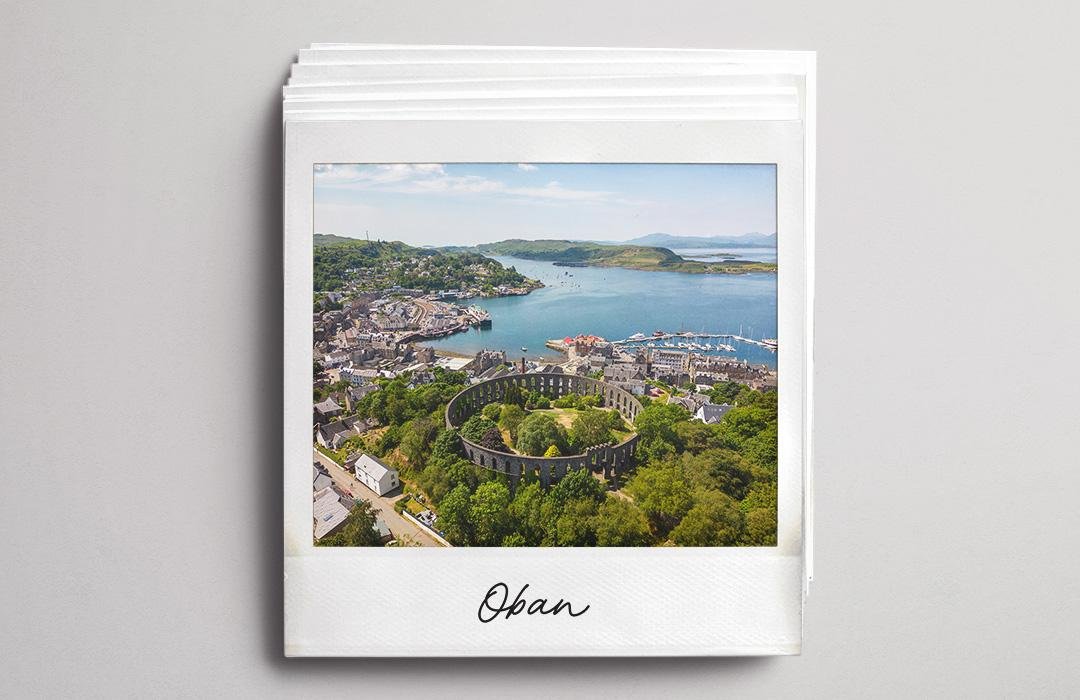 A polaroid aerial photo of Oban harbour and the surrounding hills.