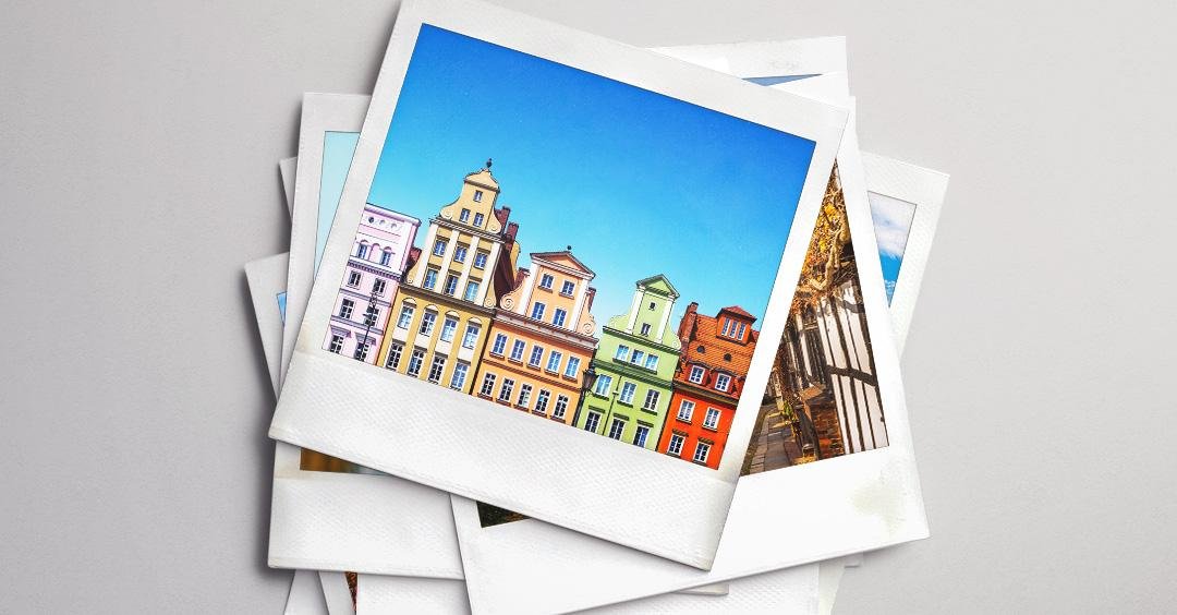 A stack of polaroid photos showing colourful townhouses in a whimsical European town.